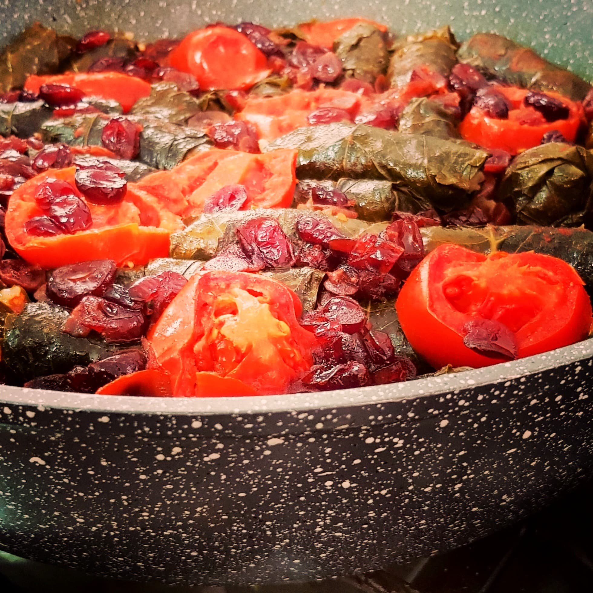 דולמה — עלי גפן ממולאים אורז ועשבי תיבול, מוגשים עם עגבניות אפויות