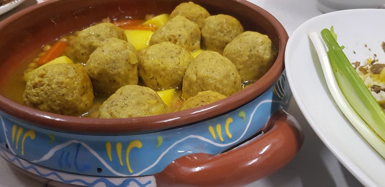 גונדי — כדורי עוף בקמח חומוס במרק, מוגשים בקערת פרסית מסורתית