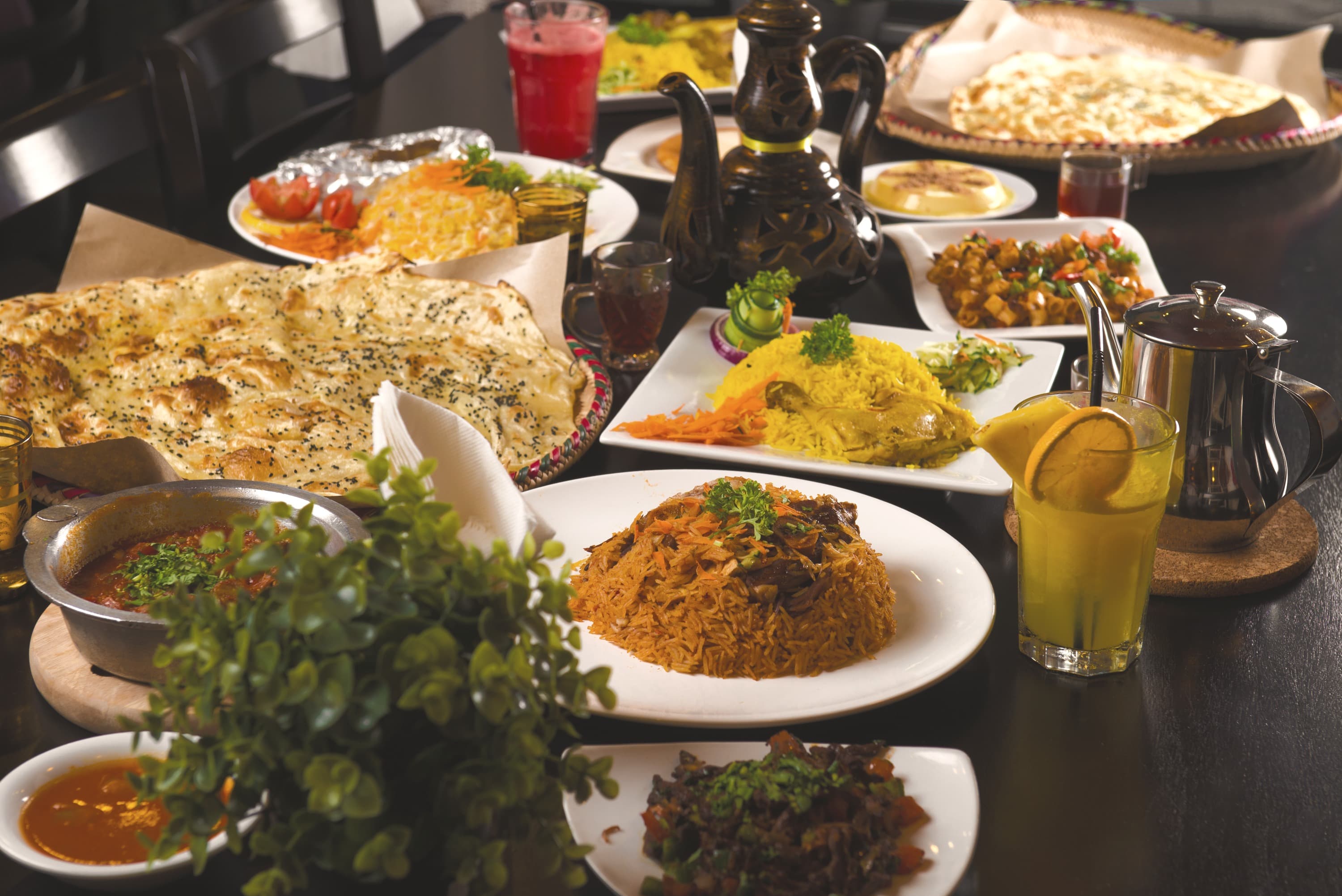Persian feast table at Lili Twizer's home — saffron rice, home-baked bread, khoresht and Persian lime alongside copper lanterns